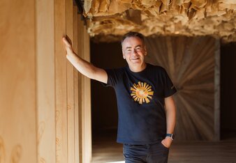 Na fotografii je ředitel a spolumajitel českého SONNENTORU, Josef Dvořáček. Opírá se o dřevěnou lamelu na okně exkurzní trasy v Bylinkovém ráji SONNENTOR. | © SONNENTOR